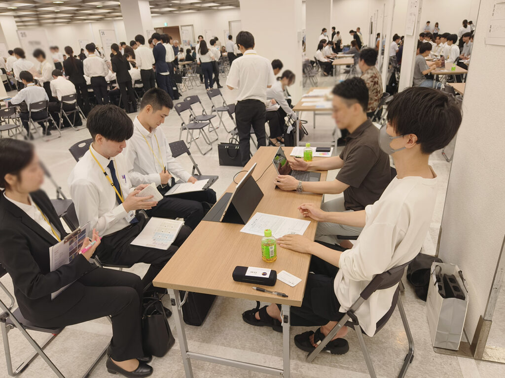 企業ブースで説明を受けている